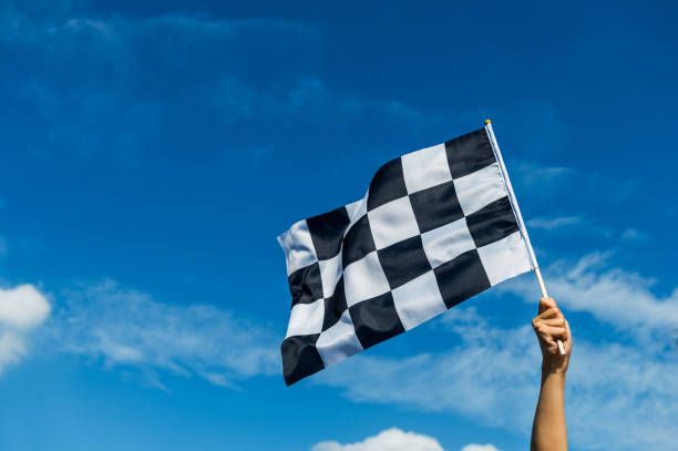 Hand holding checkered race flag in the air Hand holding checkered race flag in the air the end stock pictures, royalty-free photos & images