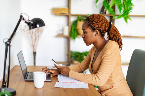 istock Young Black Woman Working From Home Using Laptop 1415424233