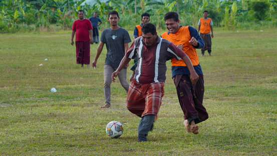 Parents and young people take part in football wearing sarongs to celebrate Indonesia's 77th Independence Day in Banda Aceh on August 17, 2022