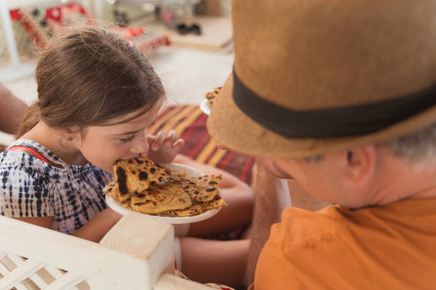 istock Girl taking a bite of her dad's Turkish pancake 1415424929