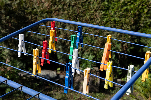 Different colored pegs on a clothes horse in the garden.
