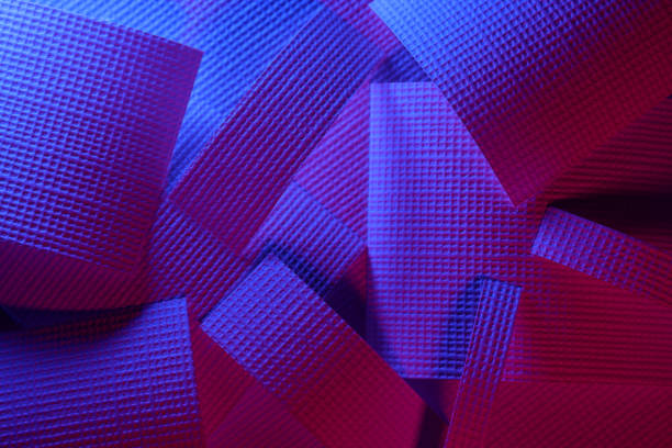 Abstract background of geometrical shaped papers under neon lights with copy space