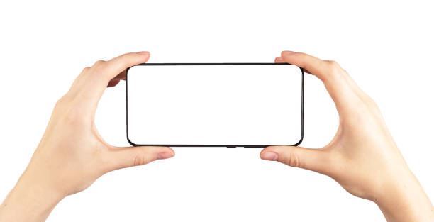 istock Hands holding phone mockup in horizontal position isolated on white background. Woman using smartphone for watching video. Telephone template with blank display. 1415431816