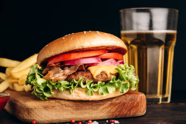 istock Burger hamburger with crispy bacon and potatoes fries on a dark background 1415435152