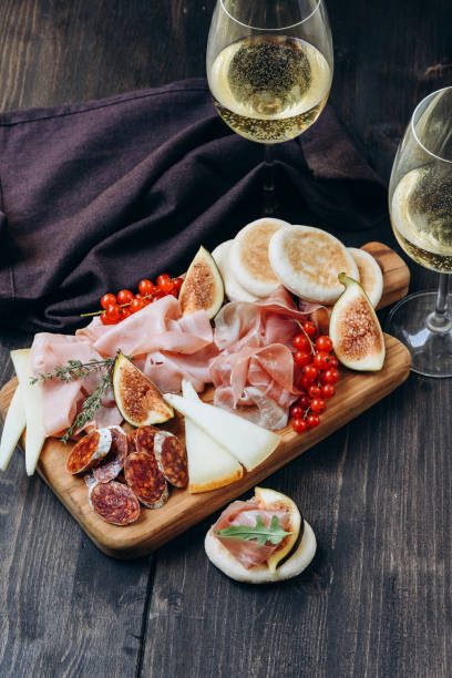 antipasto는 prosciutto, 살라미, 무화과와 열매가있는 치즈와 함께 차가운 고기 접시를 플래터링합니다. 와인 또는 프로 세코 유리 - food italian cuisine cheese salami 뉴스 사진 이미지