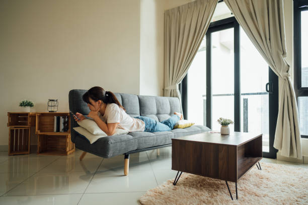 istock Female Resting on Comfortable Sofa. She's Browsing the Internet and Checking Videos on Social Networks and Having Fun. 1415436675
