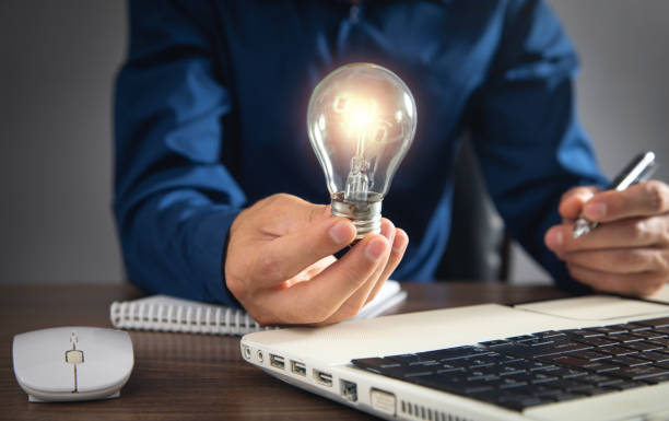 istock Man holding light bulb and working at office. 1415438688