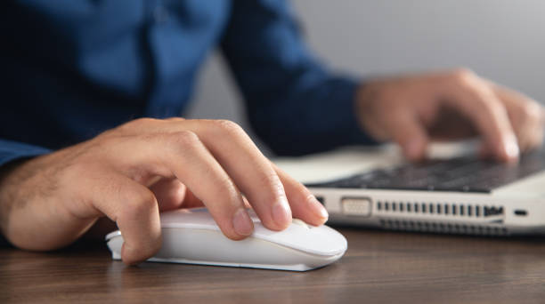 istock Male hand clicking computer mouse and typing in computer keyboard. Internet. Business. Technology 1415438696