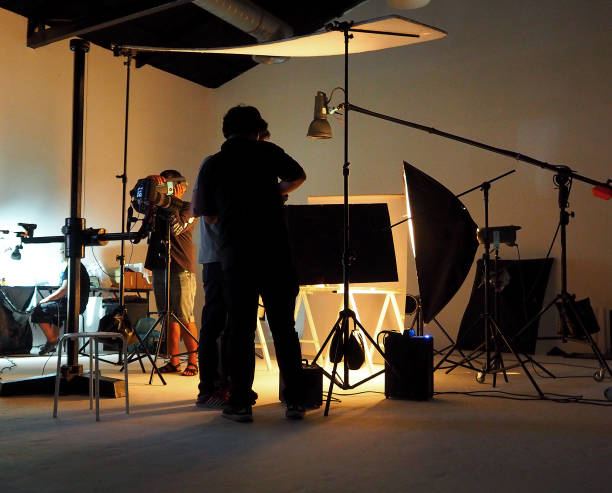 istock Silhouette of people working in production studio for shooting or recording by digital camera and lighting set. 1415441002