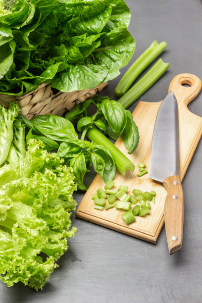 istock Chopped celery stalks, kitchen knife on cutting board. Lettuce leaves in wicker basket. 1415441519