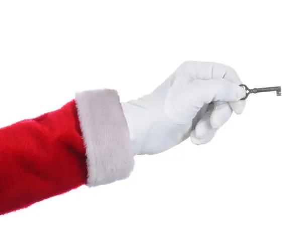 Santa Claus holding an antique key over a white background.