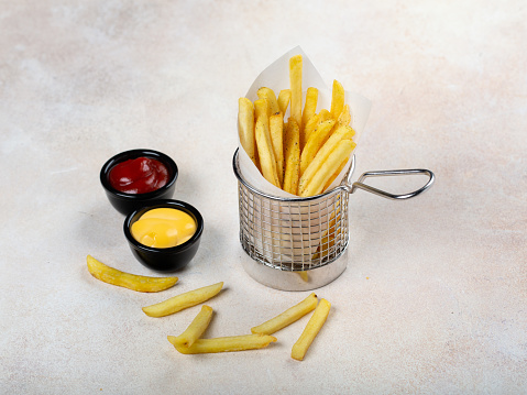 french fries in basket with ketchup and cheese sauce