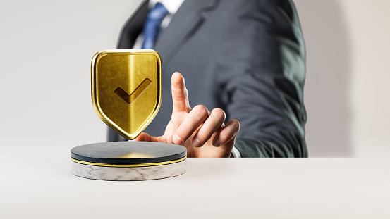 businessman with golden shield icon on a stage in front of white background