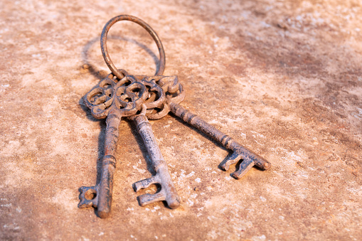 Old rusty key on grunge background. Vintage door keys. Antique keys on weathered rusty background. Aged iron key with copy space.