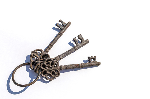 Three old antique metal keys on white background