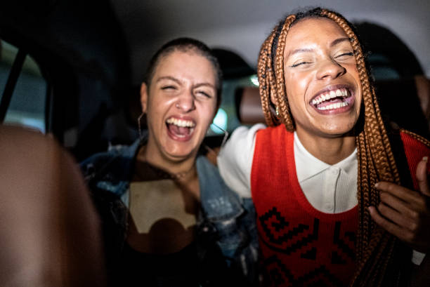 istock Friends talking and laughing in the car 1415444418