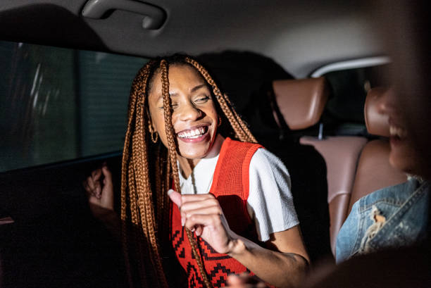 young woman laughing with a friend in the car - image singing fun vacations imagens e fotografias de stock