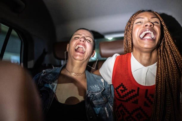 istock Friends talking and laughing in the car 1415444442