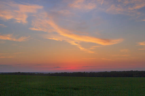 istock Colorful bright sunset in the field with clouds. 1415444764
