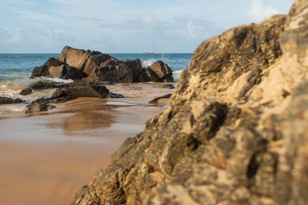 istock A wave breaks about a rock during a curtain on the sea. 1415447276