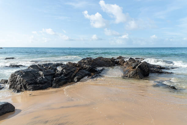 istock A wave breaks about a rock during a curtain on the sea. 1415447295