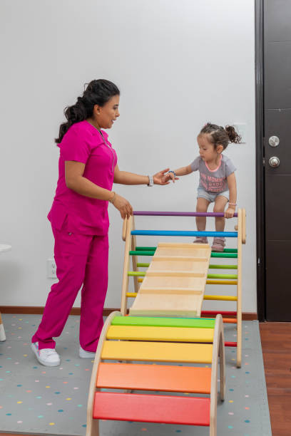 un pédiatre aide une fille à grimper sur un jeu en bois qu’il a dans son bureau - doctor domestic room cabinet cabinet member photos et images de collection