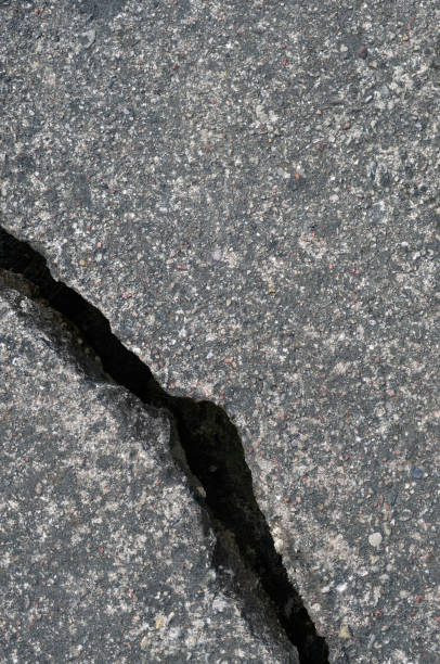 istock Old aged weathered cracked grey black tarmac texture pattern, large detailed damaged textured asphalt grungy background flat lay, vertical rough grained broken pattern macro closeup grunge copy space 1415449802