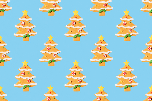 Seamless New Year's pattern from Christmas tree toy in form of spruce tree made of cookies on blue background. Christmas and New Year concept