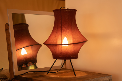 View of a cozy decorative corner with a table lamp spending warm light.