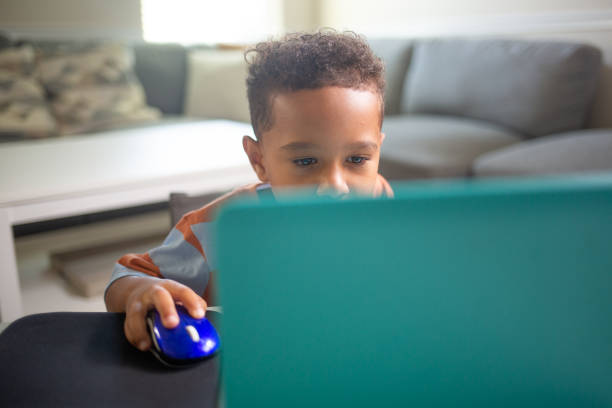 istock Face covered Mixed 3 year Old Boy learning on the Laptop Computer 1415451520