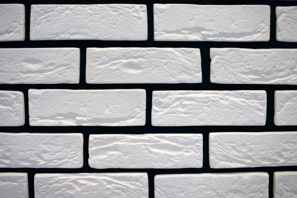 istock White facade background. Design element. Background of white bricks and black cement 1415451590