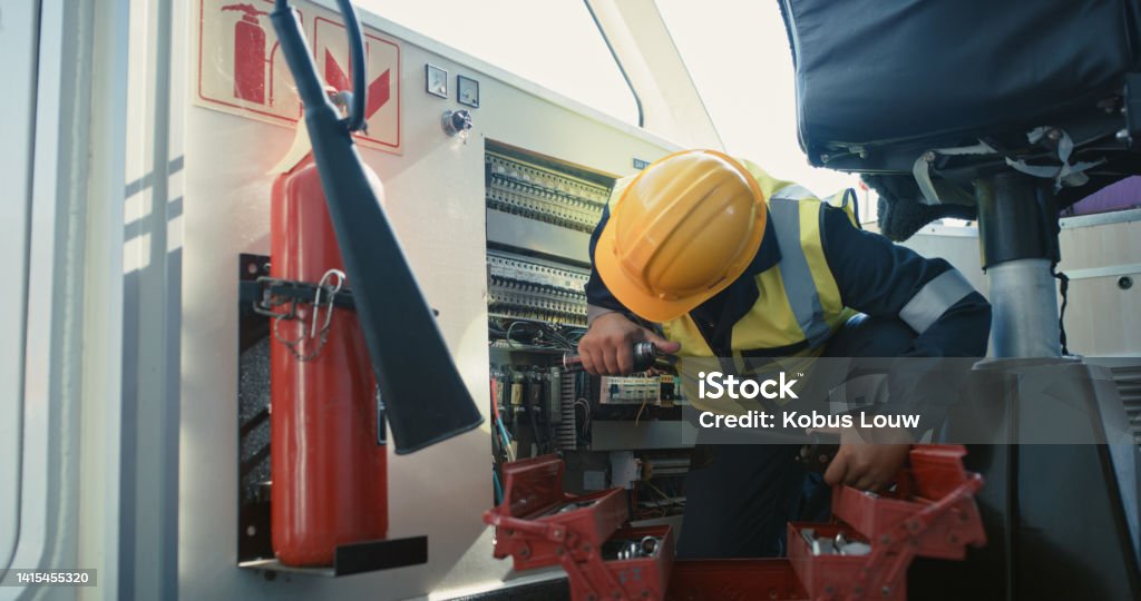 Mechanical engineer fixing, repairing and doing maintenance on ship equipment, air vents and freight motor. Mechanic, technician and logistics worker with a toolbox checking and monitoring cargo boat Electric Switchboard Stock Photo