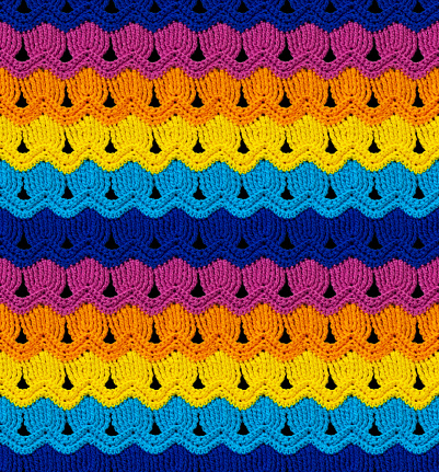 Seamless knitted texture. The pattern is crocheted from bright contrasting colors of acrylic yarn. Ethnic color motifs.