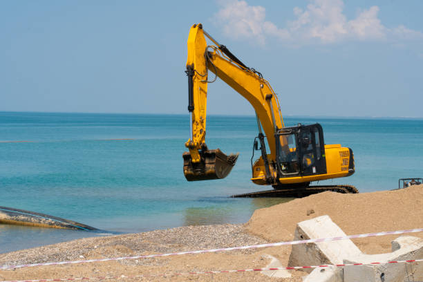 istock Excavator loading quarry truck dump tractor machinery machine loader heavy, from backhoe soil for dig and sky work, bucket crawler. Mud rotate yellow, 1415459022