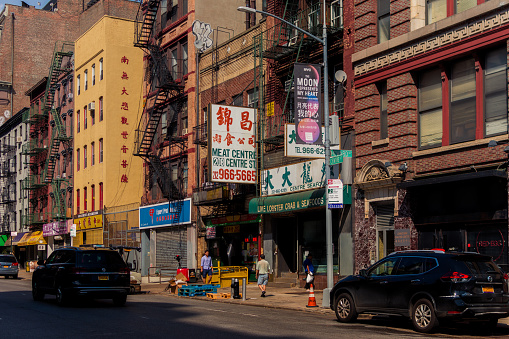 Main Street, Flushing downtown, Queens, New York, NY, USA - July 2 2022: Small Chinese shops and a tall residential building