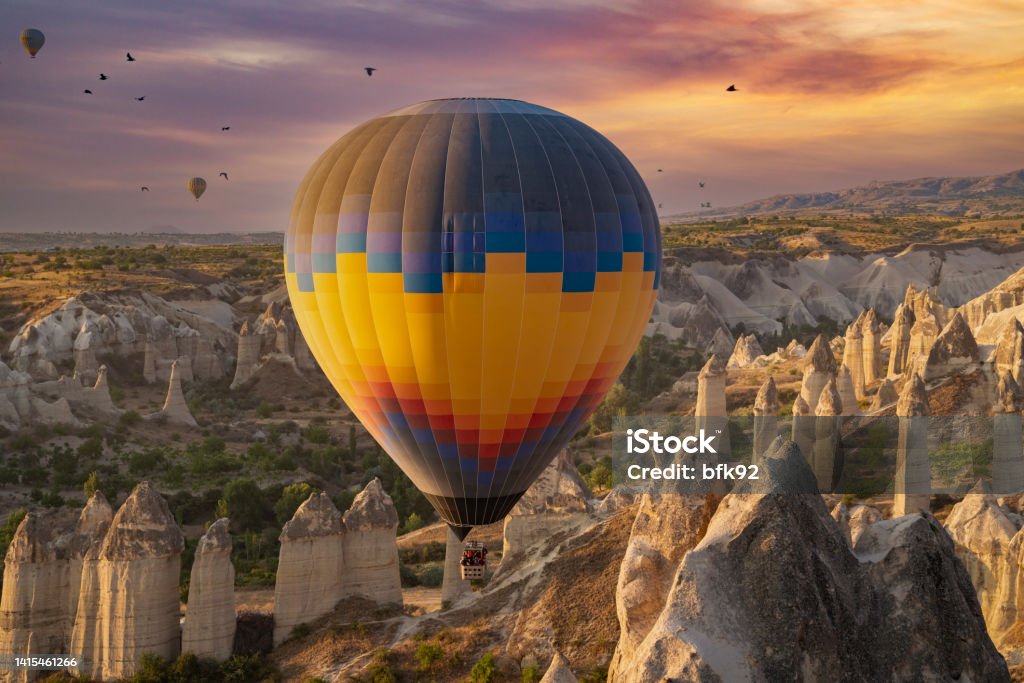 Stunning morning view and balloons in Cappadocia taking off at sunrise. Stunning morning view and balloons in Cappadocia taking off at sunrise. Every day over 100 balloons fly taking tourist on a magical view of Nevsehir. 2022 Stock Photo