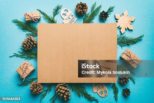 istock Flat lay Christmas composition. square Paper blank, pine tree branches, christmas decorations on Colored background. Top view, copy space for text 1415464353