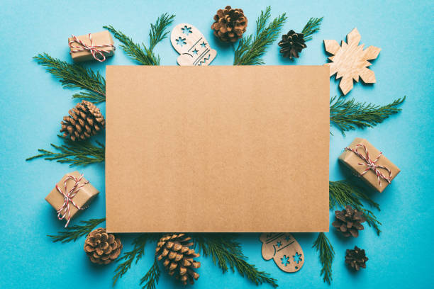 Flat lay Christmas composition. square Paper blank, pine tree branches, christmas decorations on Colored background. Top view, copy space for text stock photo