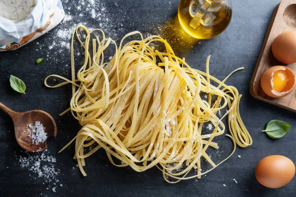 Homemade pasta spaghetti on dark background. Top View. Italian food concept.