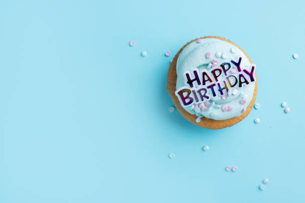 istock Happy birthday muffin on blue 1415464685