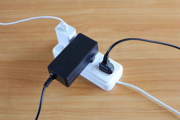 istock Different devices plugs are connected to multiple outlets of energy on wooden surface 1415465628