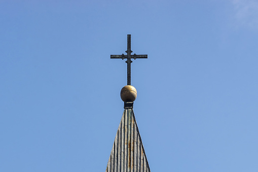 Bucharest, Romania - April 14, 2022: The cross on the bell tower of the Roman Catholic church Baratia, in downtown Bucharest.