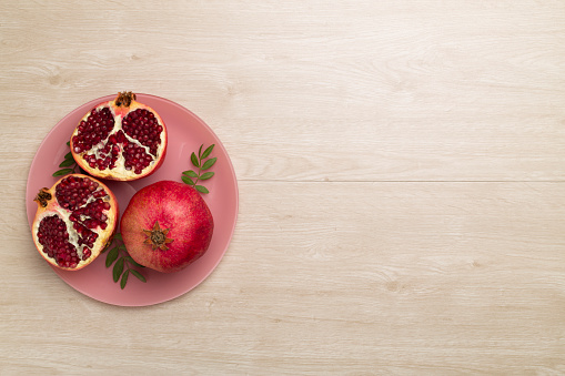 Fresh juicy pomegranate on white wooden background, top view.