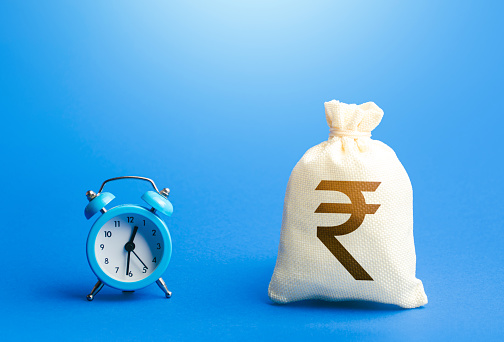Time and indian rupee money bag. Loans, mortgages. Deposits, savings. Retirement funds. ROI. Bonds, dividends. Bank, finance. Investments. Hourly pay. Time of payment in the contract. Taxation