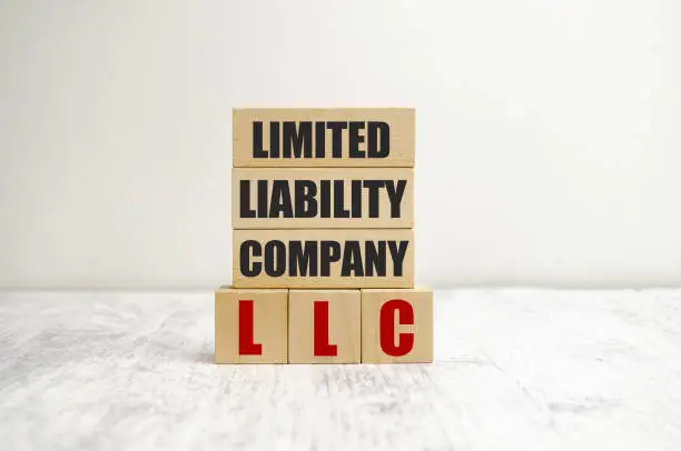 Photo of letters of the alphabet of LLC on wooden cubes and white background