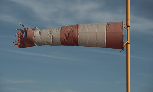 A torn windsock during a strong wind. Device for controlling the strength and direction of the wind. Weather Theme