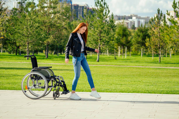 istock redhaired ginger woman making first steps after long recovery.she walking without her wheelchair in spring park 1415483180