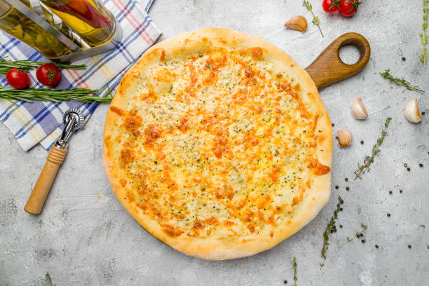 istock Pizza Quattro formaggi on the board on grey table top view 1415488712