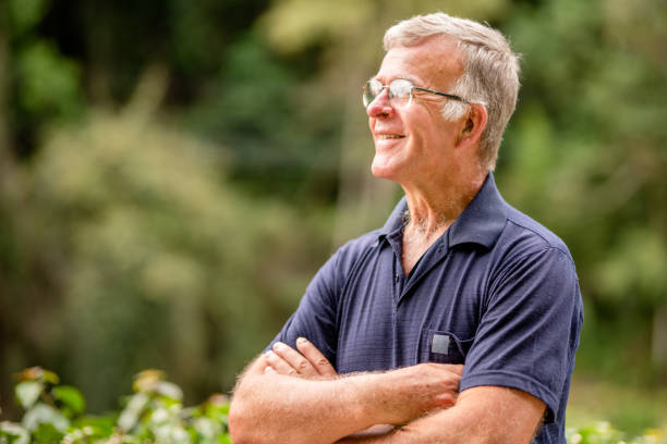istock Smiling senior man standing outside in his yard in summer 1415489968