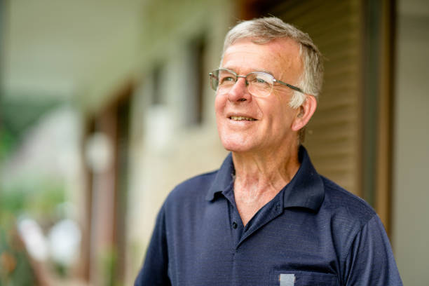 istock Senior man smiling while standing outside on his patio 1415489999